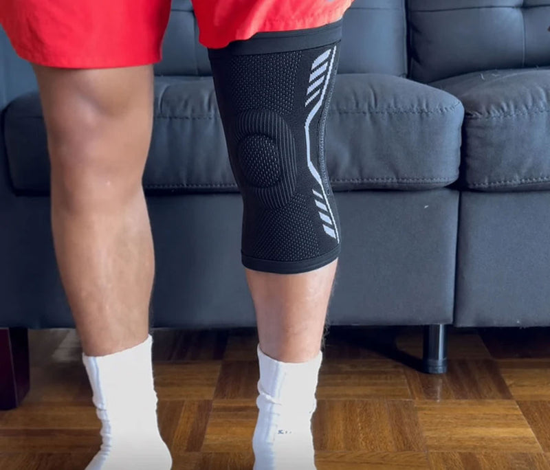 Person wearing a black TEVANLY Active Compression Knee Support Sleeve indoors.