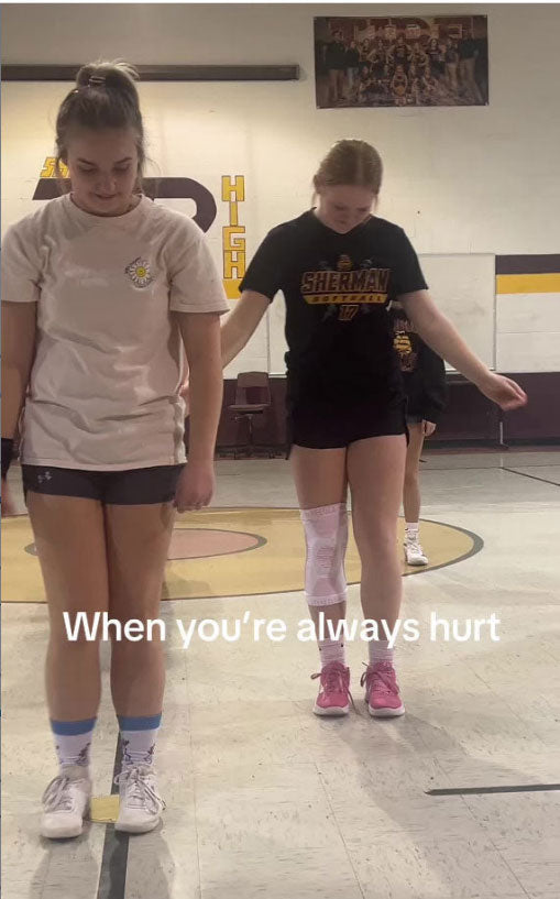 Two athletes standing in a school gym, one wearing a pink knee sleeve, with text reading, “When you’re always hurt.”