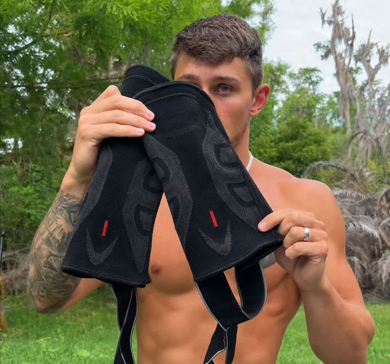 Man outdoors displaying a pair of black TEVANLY adjustable knee braces.